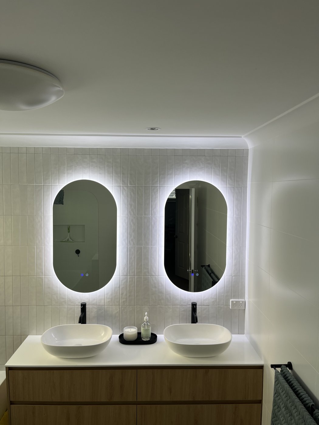 Twin backlit oval LED mirrors above a double bathroom vanity