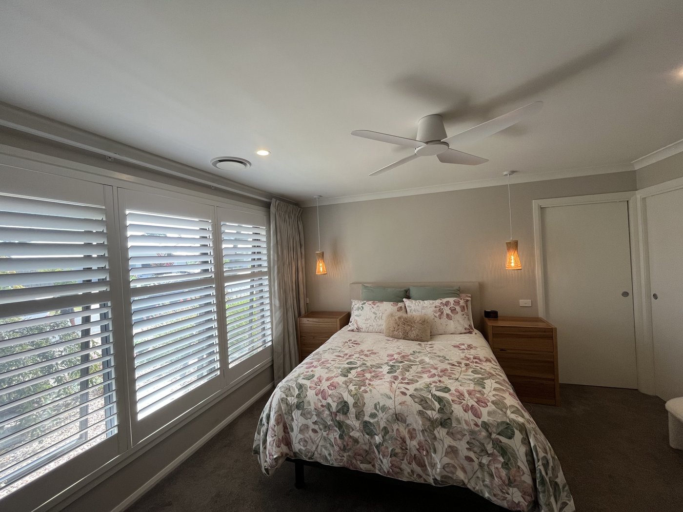 Ceiling fan and bedside pendant lights installed in a bedroom