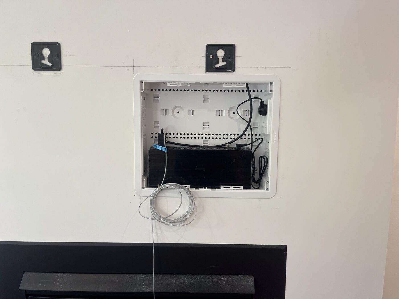 Data point and cable management recess installed behind a wall-mounted TV