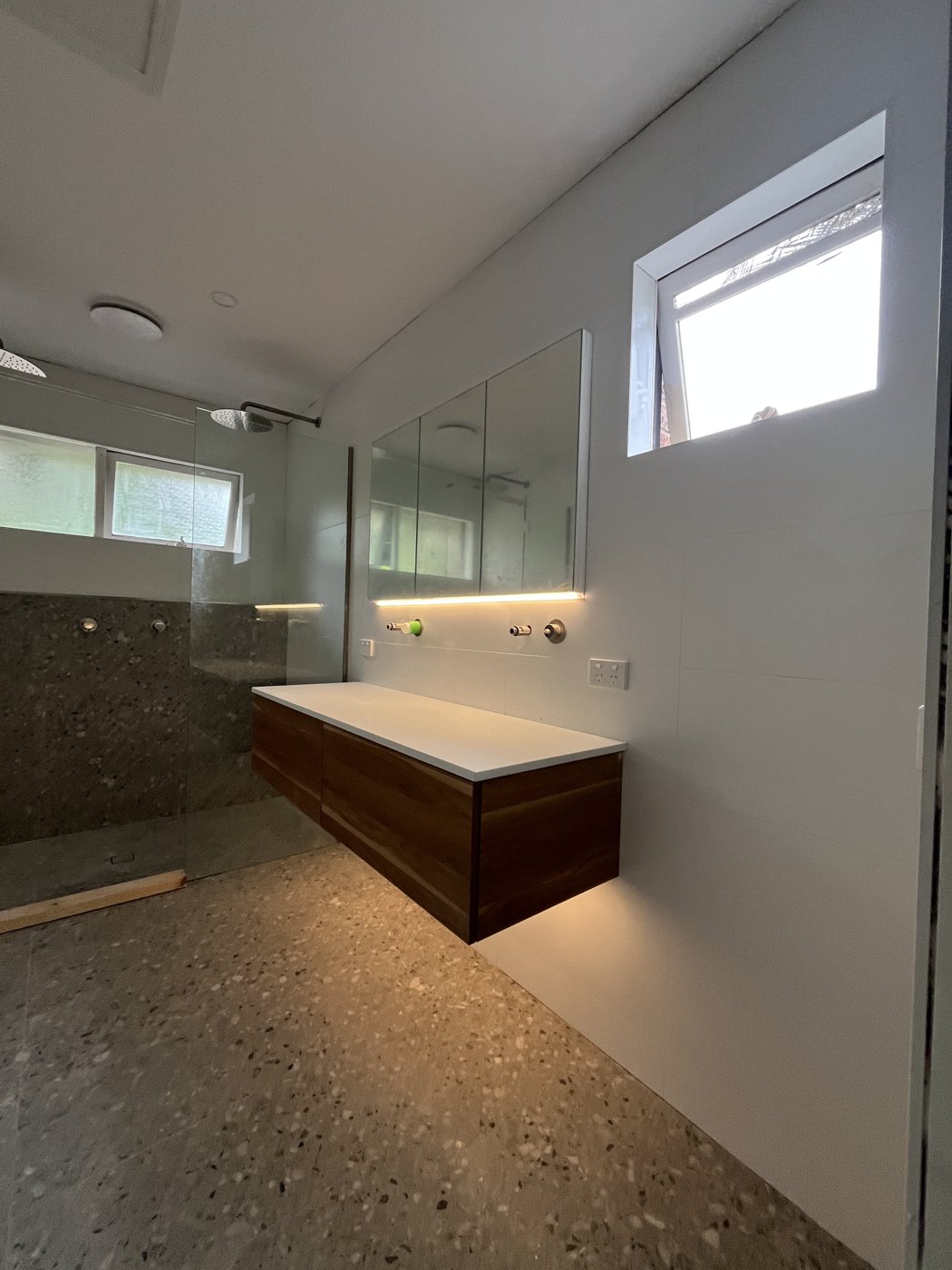 LED strip lighting installed under a mirror cabinet and floating vanity in a bathroom renovation