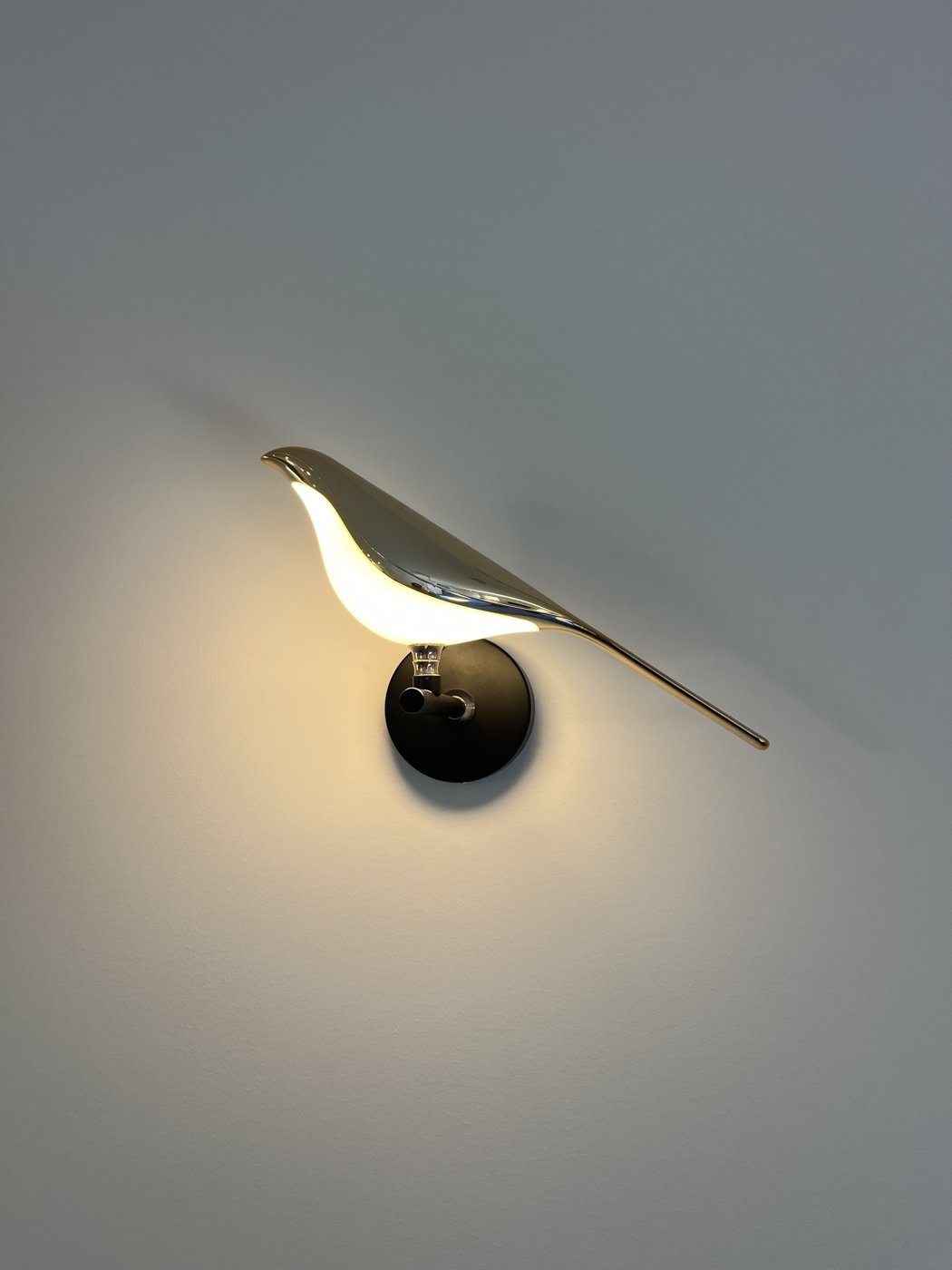 Decorative bird-shaped feature wall light installed and illuminated
