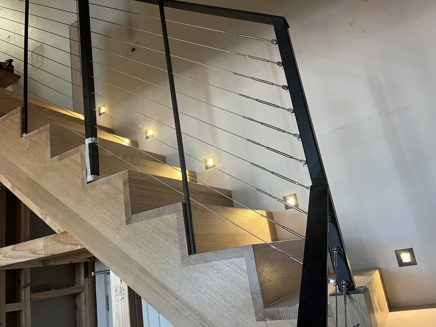 Recessed LED step lights installed along a timber staircase