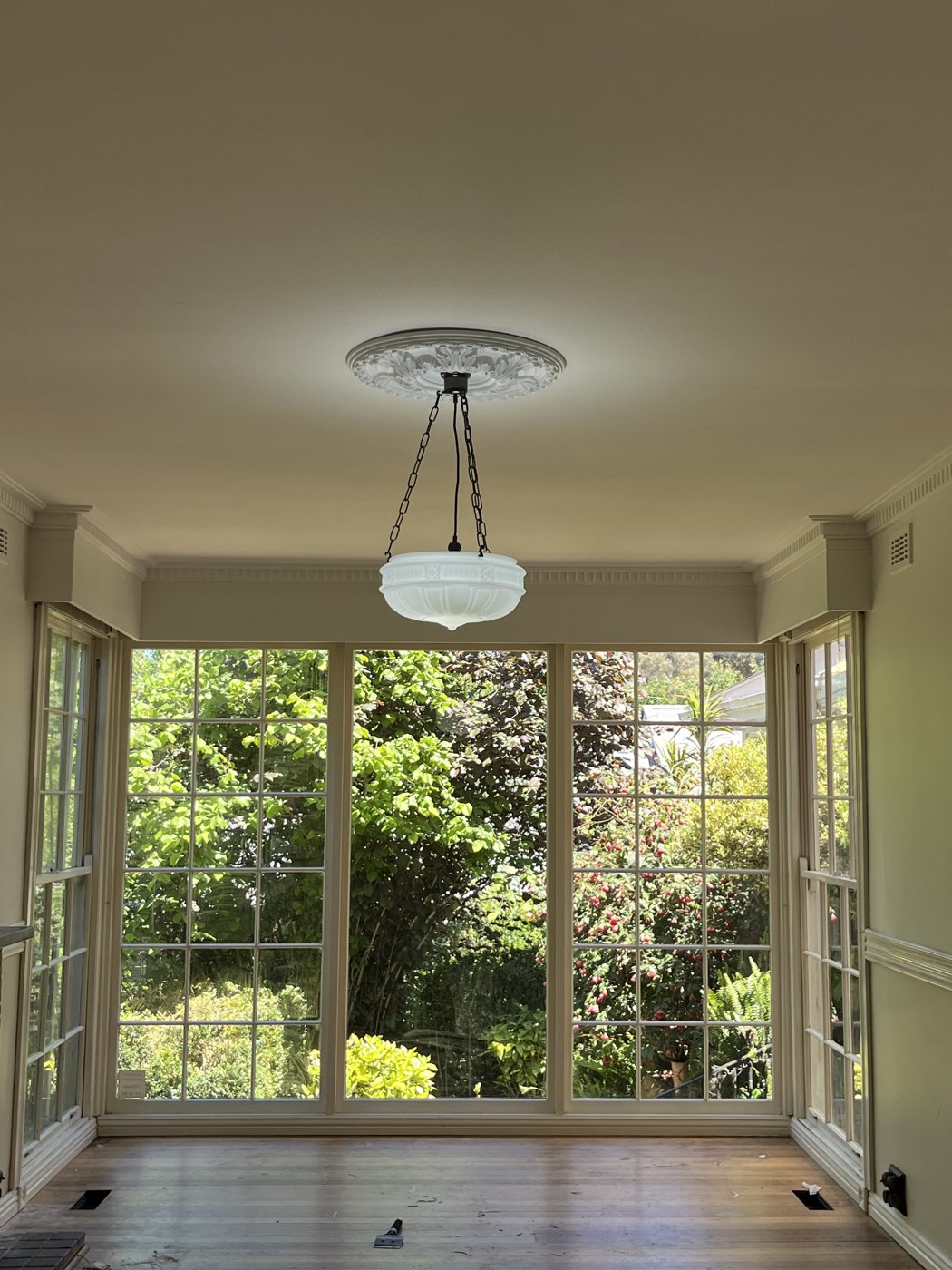 Pendant light with ornate ceiling rose installed in a sunroom
