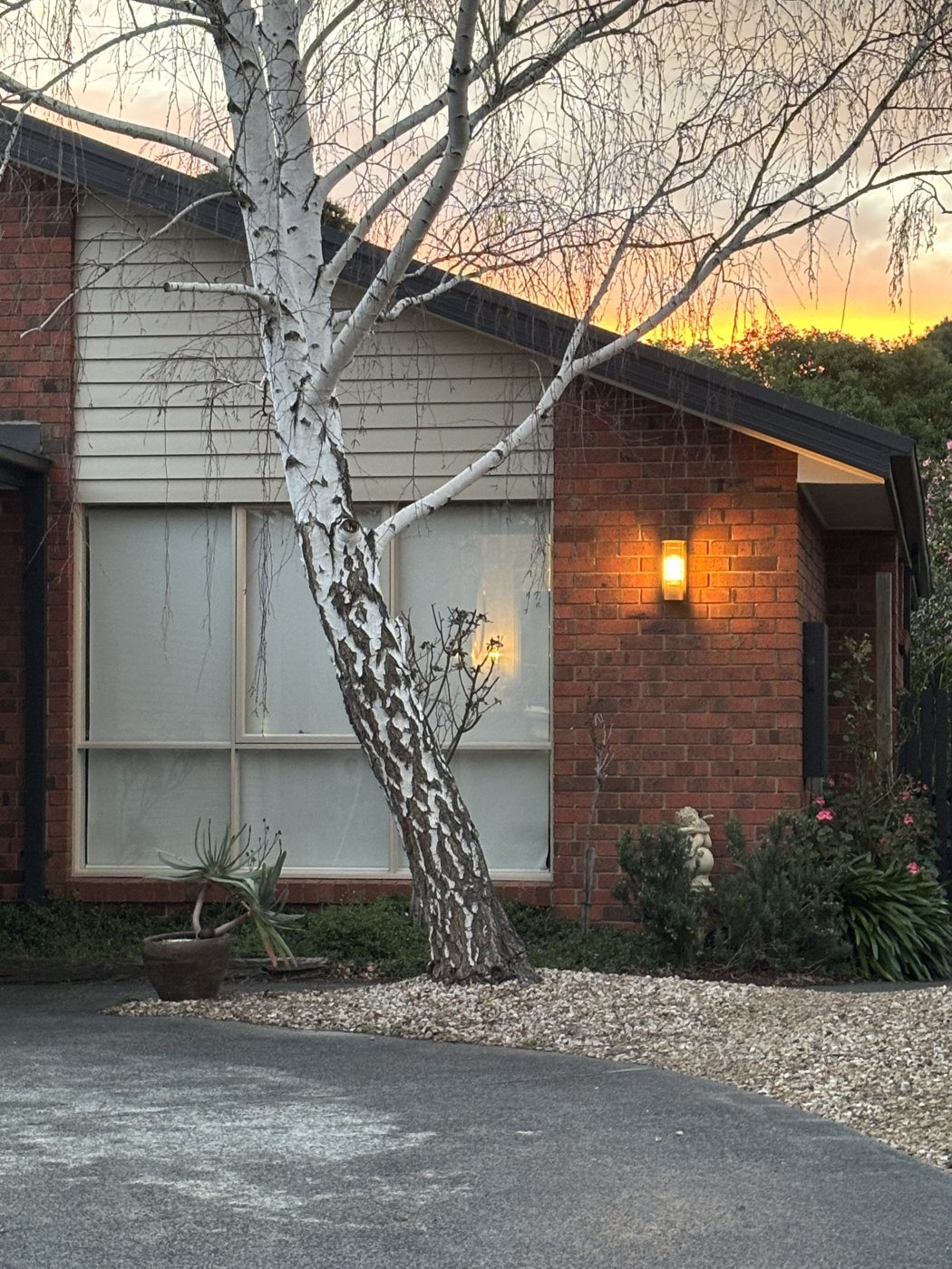 Outdoor wall light illuminated on a brick facade at sunset