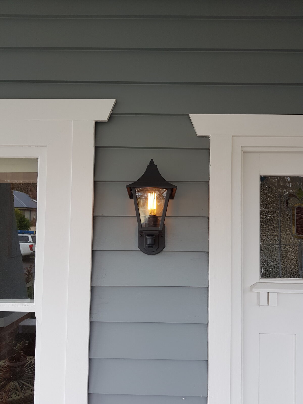 Outdoor wall light installed on a weatherboard home