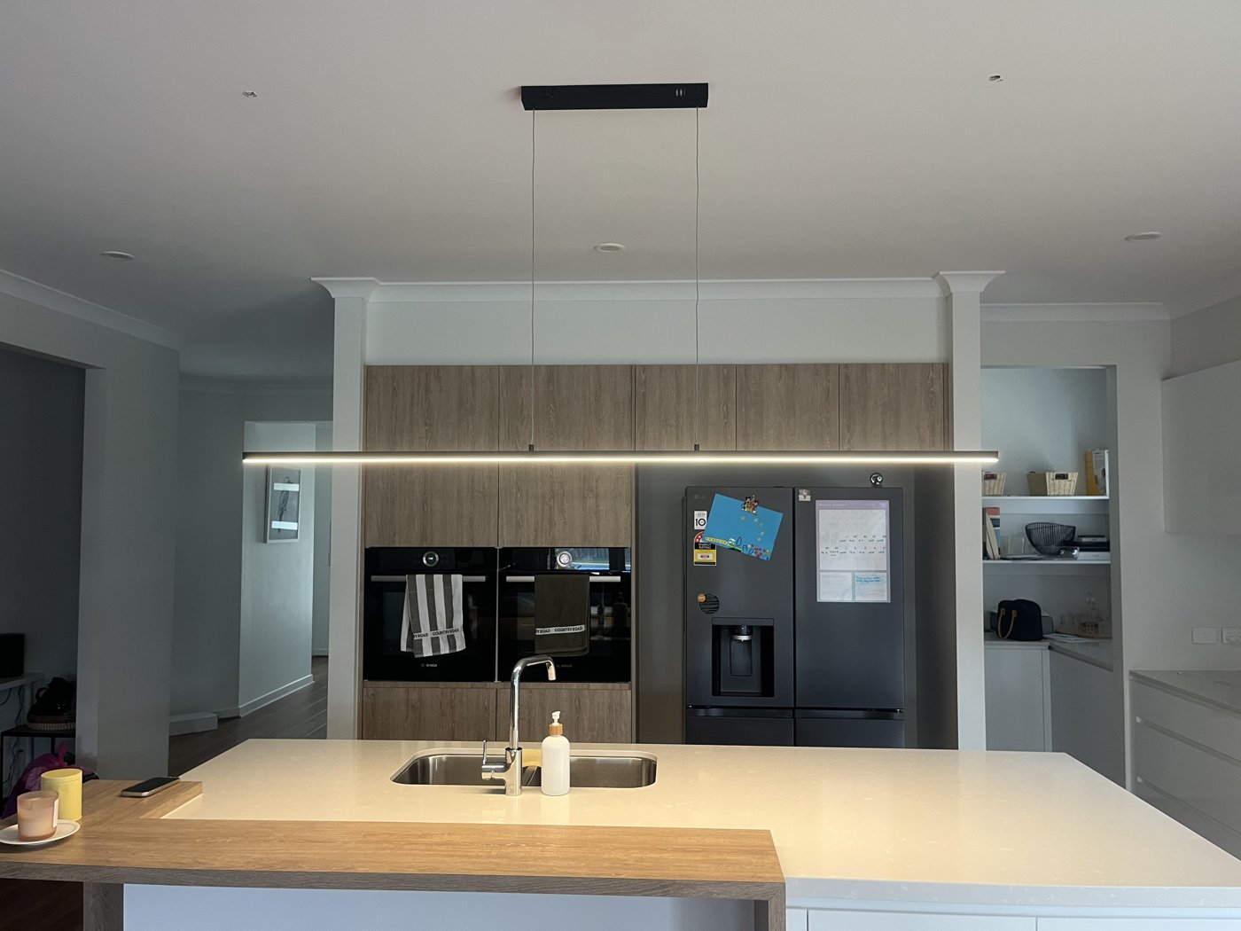 Linear LED pendant light installed above a kitchen island