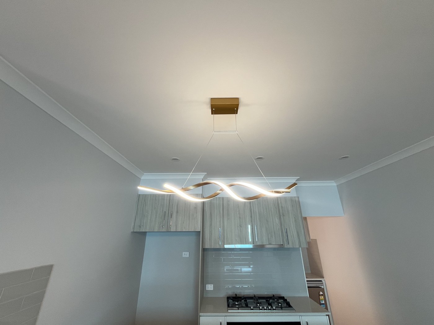 Wave-form pendant light installed above a kitchen island