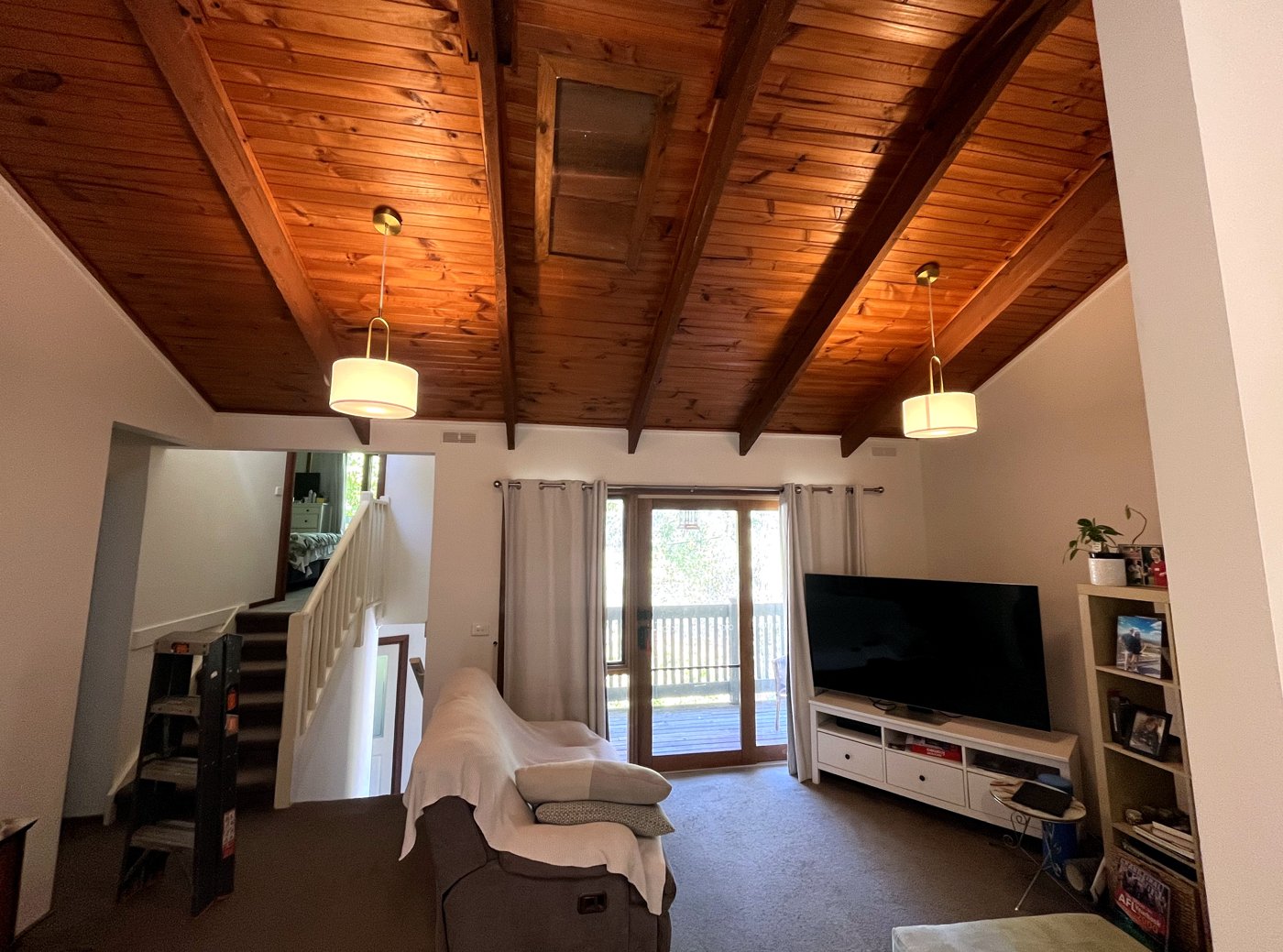 Twin drum pendant lights installed in a living room with a vaulted timber ceiling