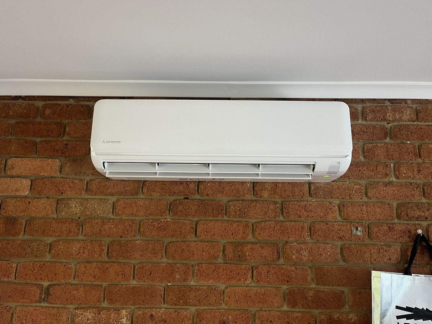Split system indoor unit mounted on an exposed brick wall
