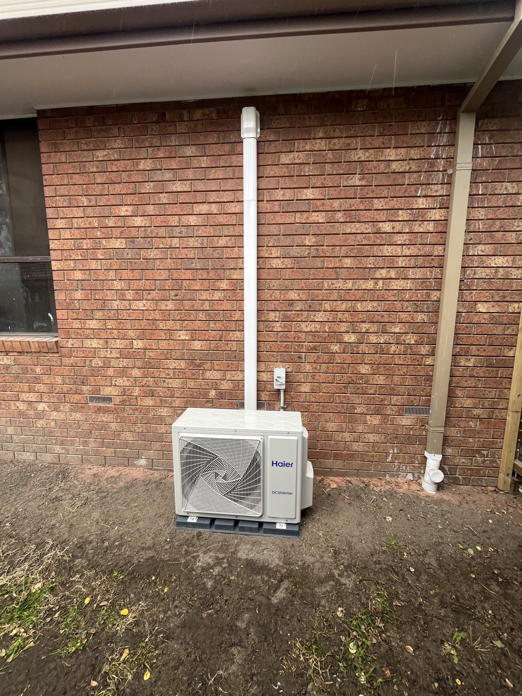 Haier split system outdoor unit installed on a brick wall