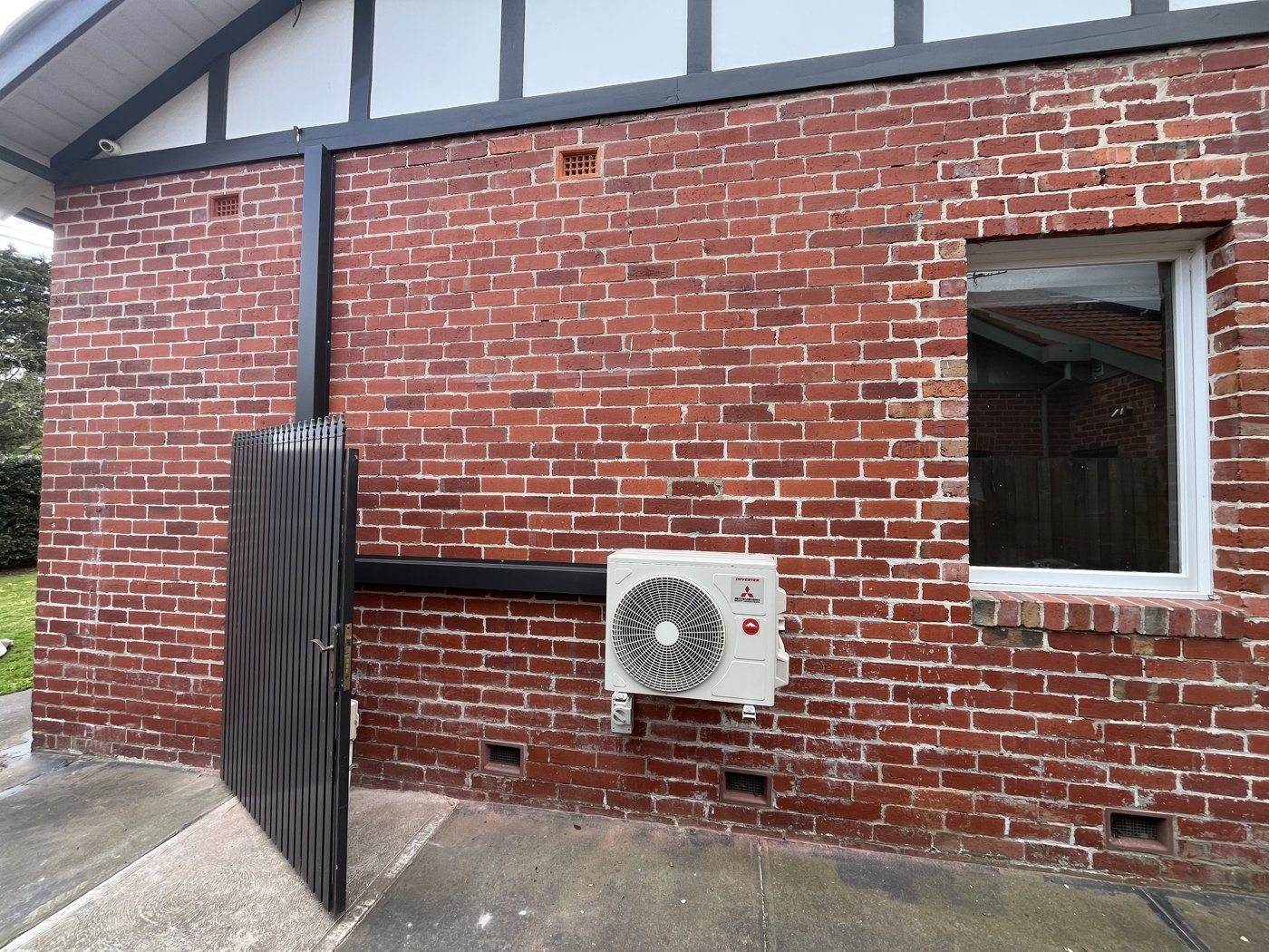 Mitsubishi split system outdoor unit installed on a period brick wall