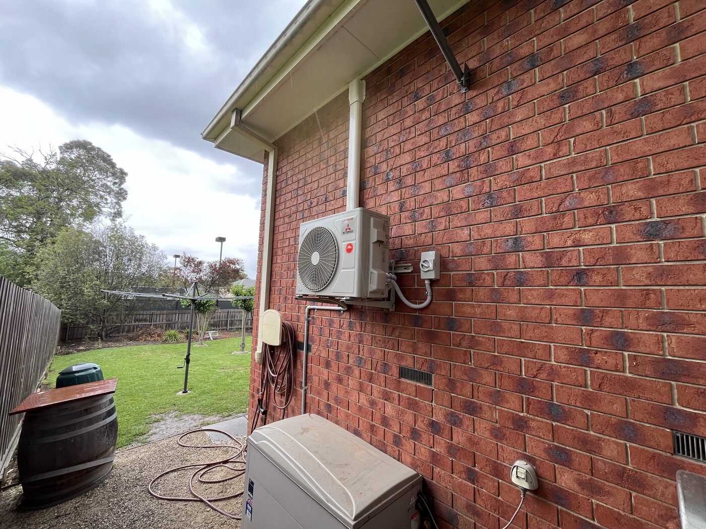 Split system outdoor condenser unit installed on an exterior brick wall
