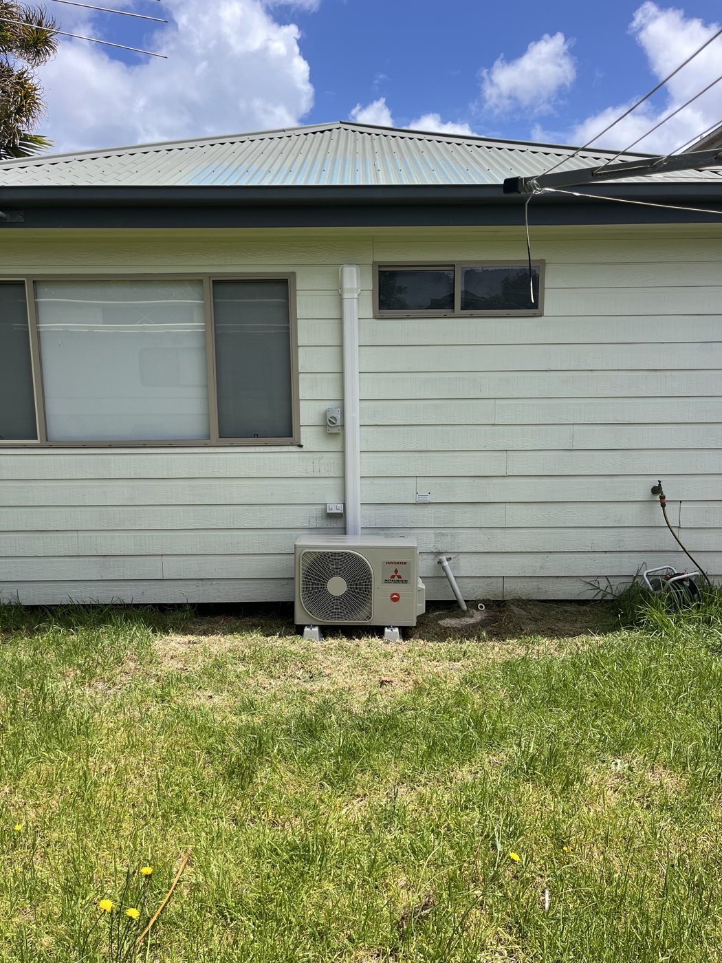 Split system outdoor unit installed on a weatherboard home