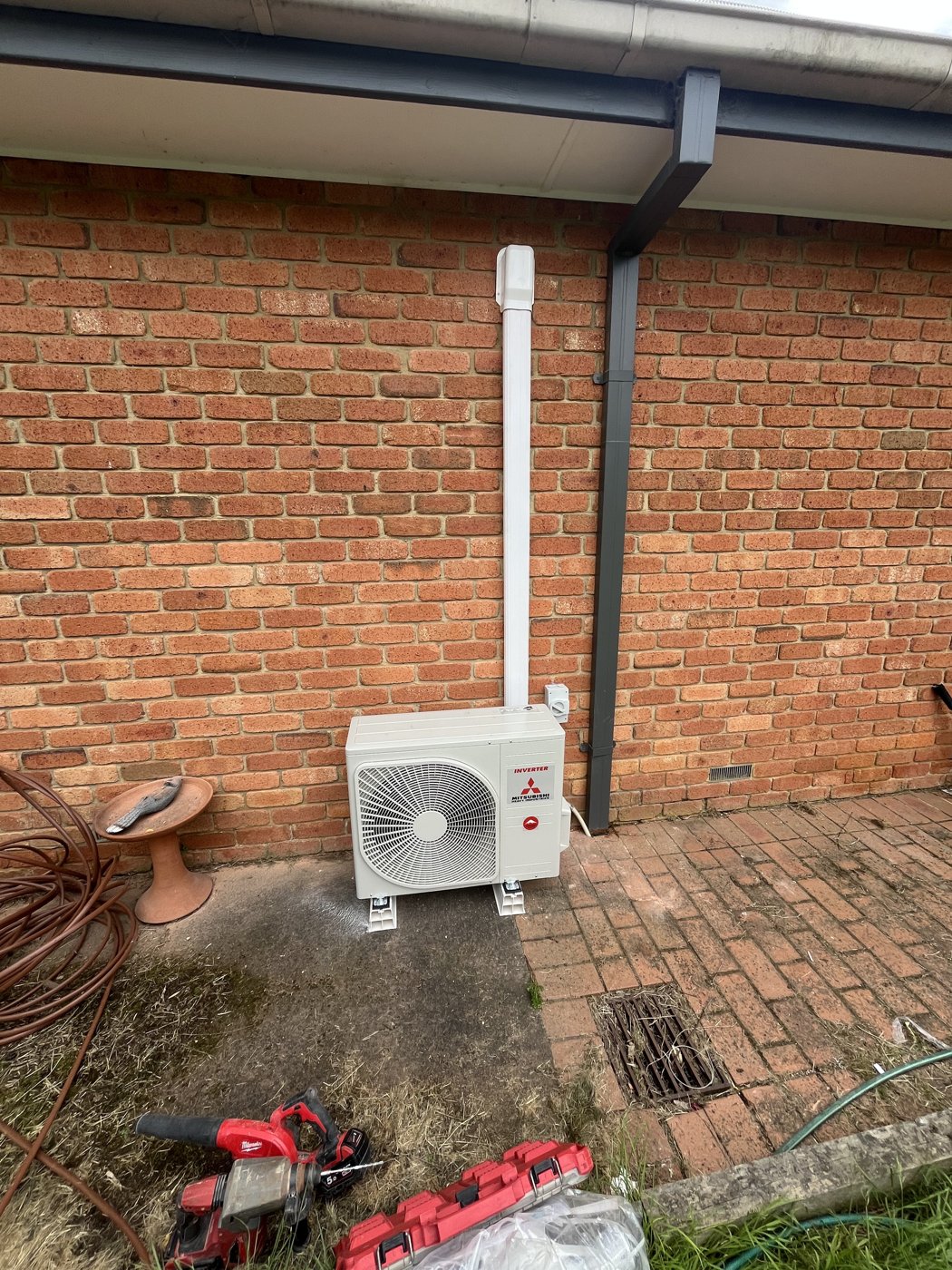 Split system outdoor unit being installed on a weatherboard home