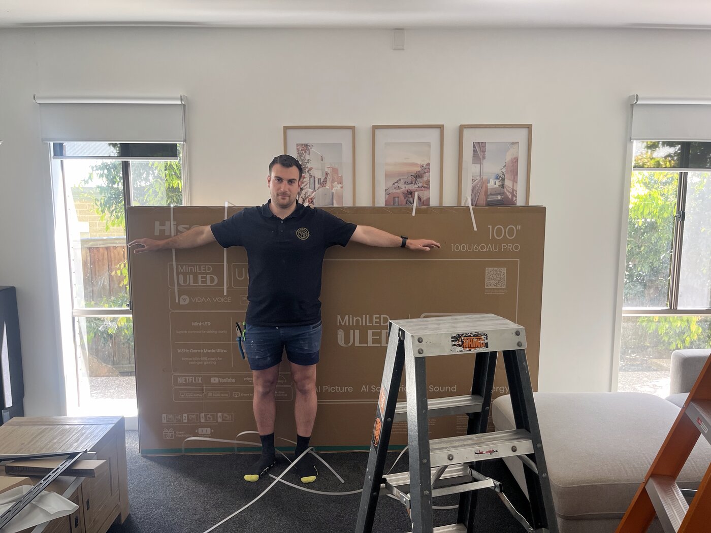 Sandy Electrical technician with a 100 inch TV ready for wall mounting